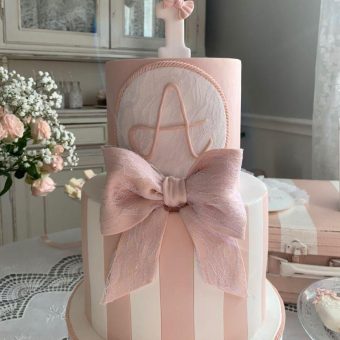 Pink cake with initial 'A' and ballet topper"